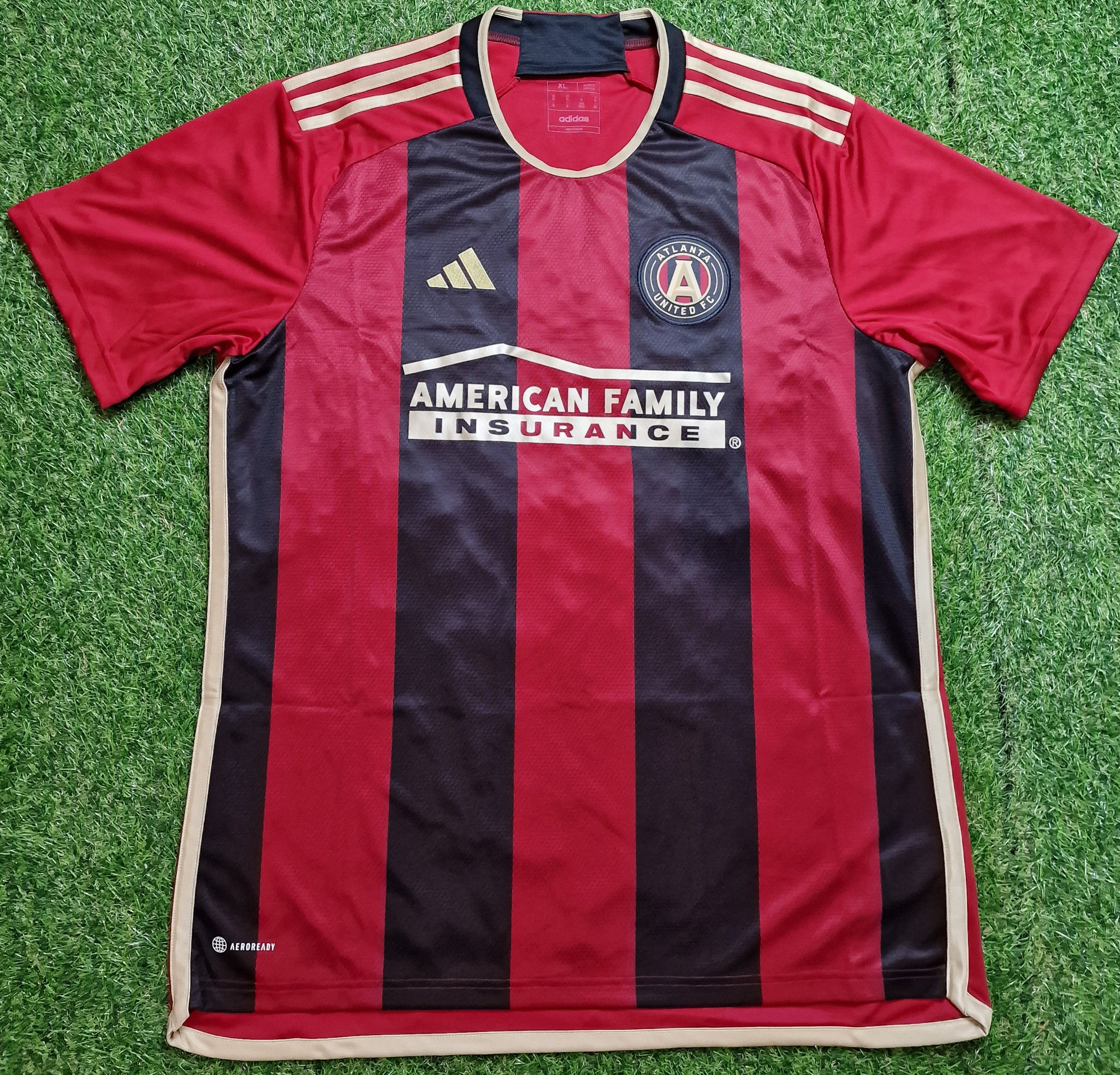 Atlanta United Home Shirt 2023-25: Red and black football shirt featuring the club crest and sponsor logos, perfect for fans of Atlanta United.