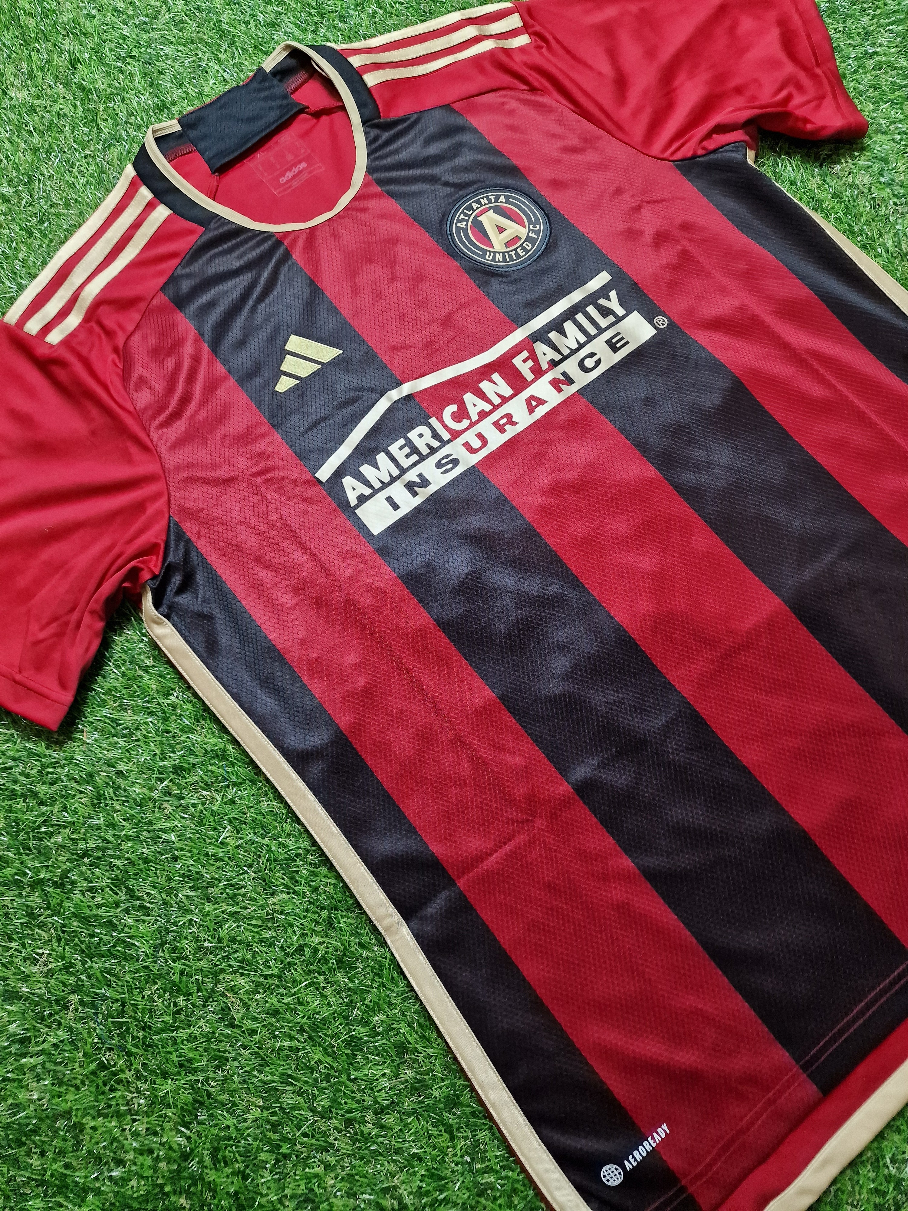 Show your support with the Atlanta United Home Shirt 2023-25: Vibrant red and black design with club emblem and sponsor details, ideal for cheering on your favorite team.