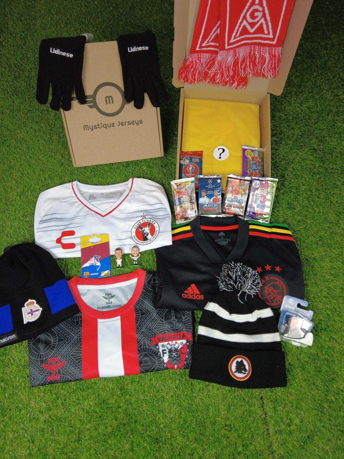 Premium Mystery Football Shirt Box: Genuine Mystery Jersey (Adult - Men), scarf, mini-figure, Mystery Cards, and one other collectible. Random selection from various teams worldwide. Includes retro, special edition, and training jerseys. 100% genuine.